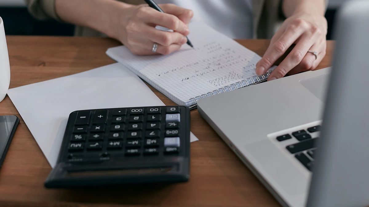 Household paperwork and a pen on a table, working through the numbers