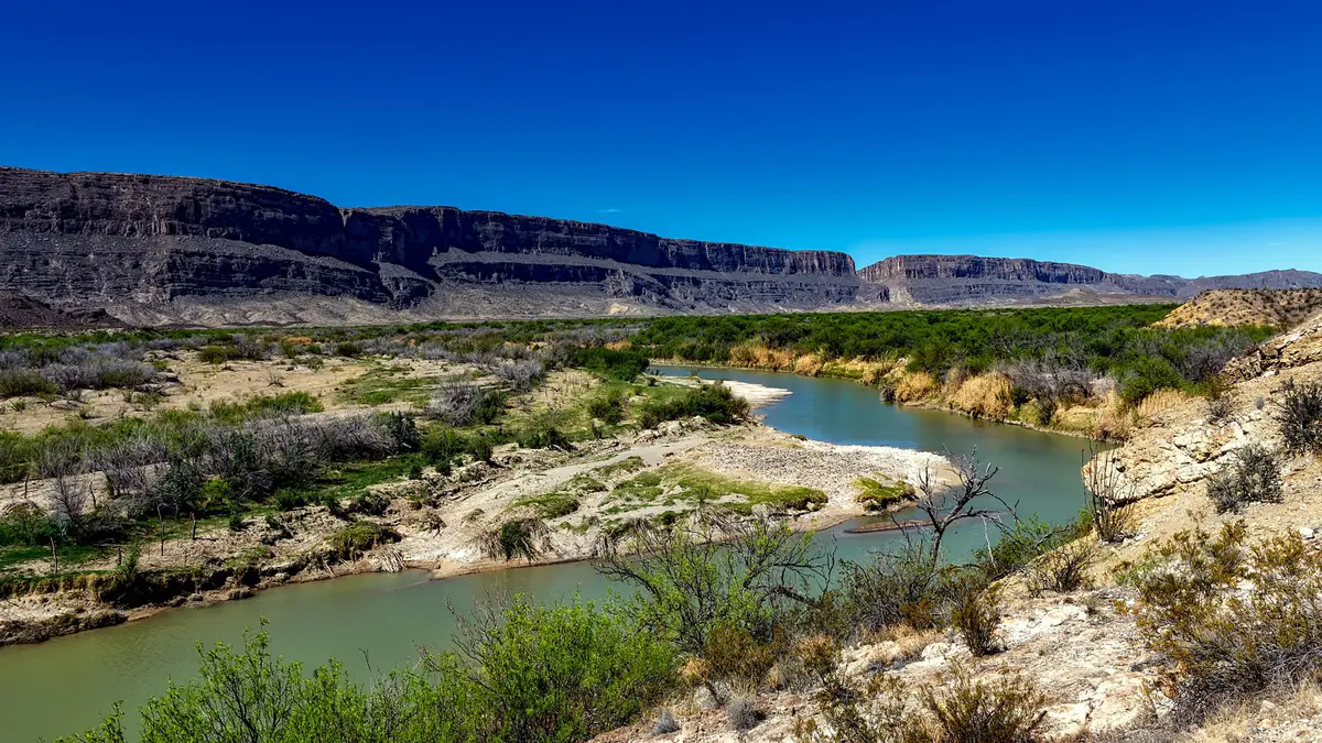 The Rio Grande winding between layered canyon cliffs in Big Bend, Texas