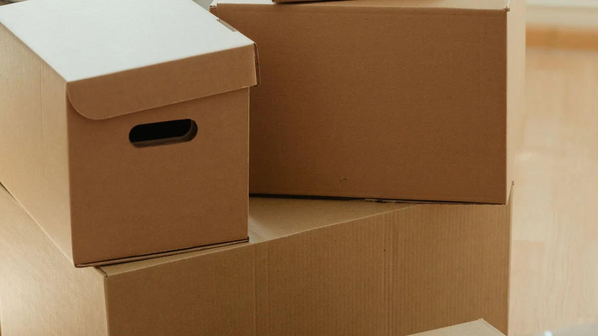 Stack of plain cardboard moving boxes, evoking a transitional move